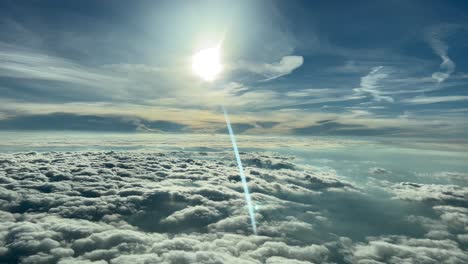 beautiful flight scene while flying at creuise level over layers of clouds and with a sunbeam reflected in the cockpit window