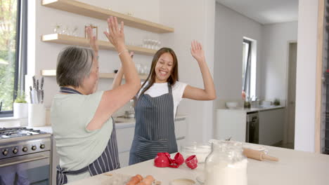 baking together, asian grandmother and granddaughter celebrating in modern kitchen