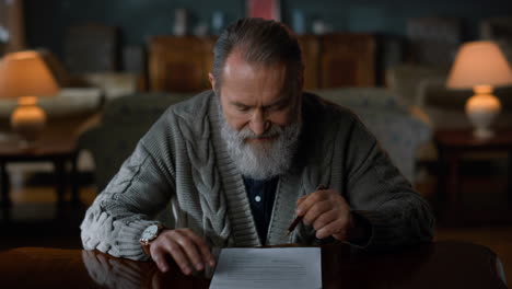 Un-Anciano-Pensativo-Haciendo-Trámites-En-Casa.-Hombre-Mayor-Firmando-Documento.