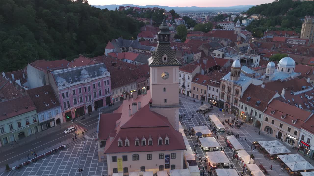Luftoptagelse der kredser om Rådhuspladsen i skumringen, og indfanger den historiske plads i Brasov, Rumænien