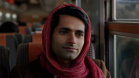 a man traveling on a train, first with a thoughtful expression and then resting with his eyes closed