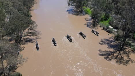 high drone shot of flooded goulburn river with muddy waters and tree lined banks