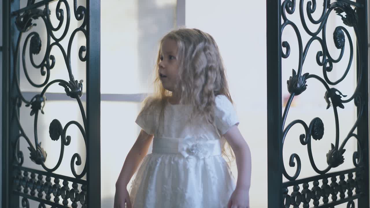 chica divertida en vestido festivo baila entre celosías forjadas