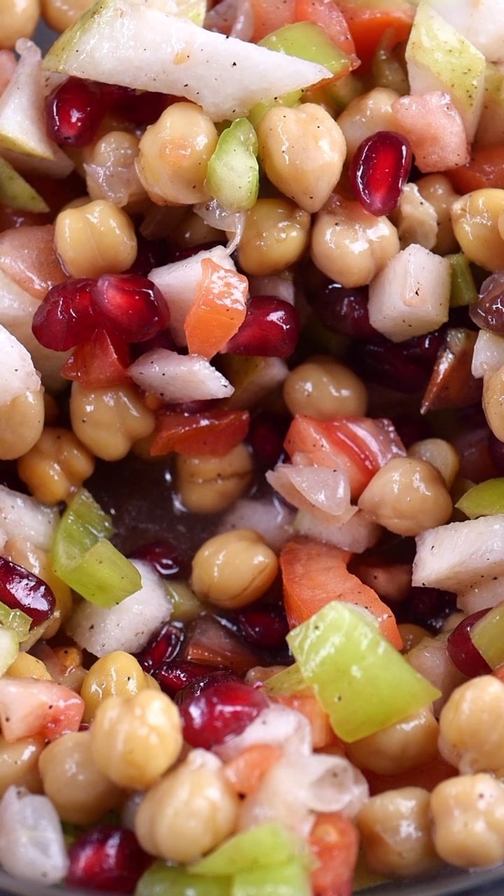 Stirring a Vibrant Chickpea Salad with Pomegranate and Apple