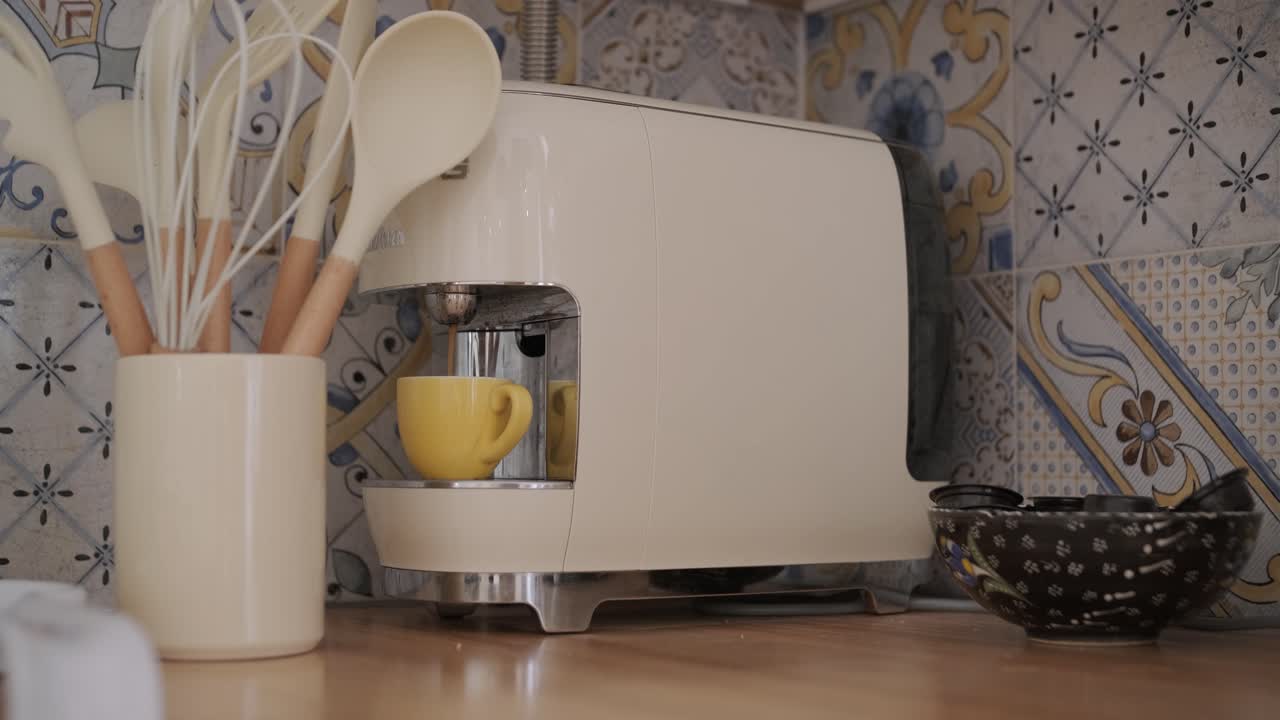 Coffee Machine Brewing Espresso into a Yellow Cup in a Kitchen