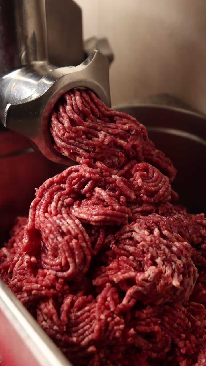 Close-up of Raw Ground Meat Exiting a Meat Grinder