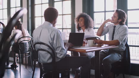 business team having informal meeting around table in coffee shop