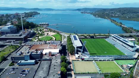 Drone-aerial-scenery-of-Gosford-city-CBD-stadium-waterfront-parks-buildings-street-infrastructure-Brisbane-Water-Central-Coast-travel-tourism-Australia-4K