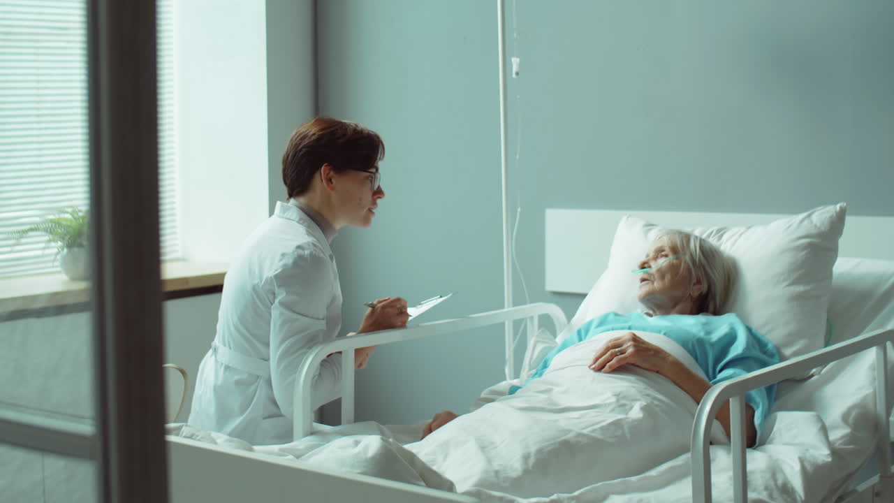 doctora que da consultas a una anciana en el pabellón del hospital