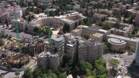 aerial view of urban landscape with buildings, construction site, and green spaces