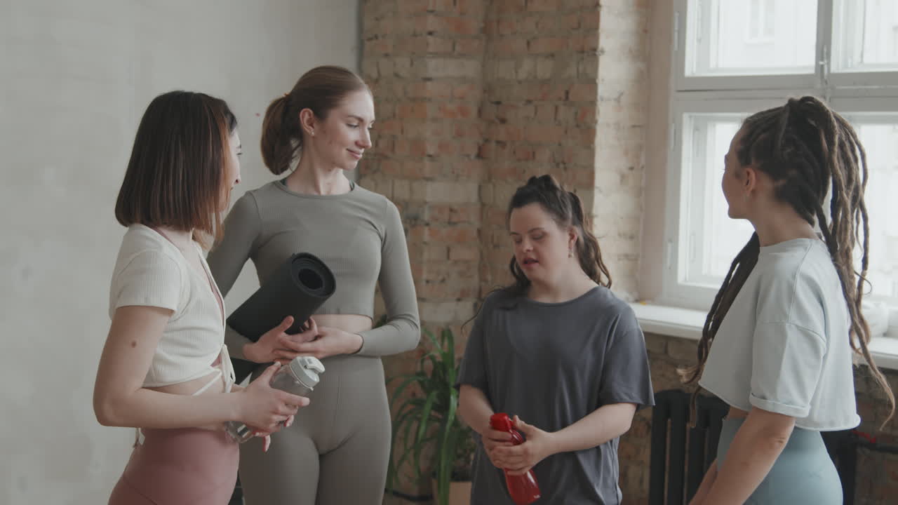 Group Of Young Women Chatting At Yoga Studio