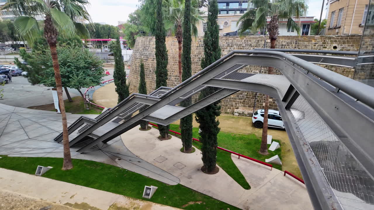 키프로스의 니코시아에 있는 혁신적인 건축 구조물로, 나무와 녹지로 둘러싸인 독특한 다리 디자인을 특징으로합니다.