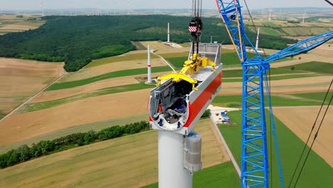 construcción de la cabeza de la turbina eólica con una grúa enorme - disparo aéreo de un dron