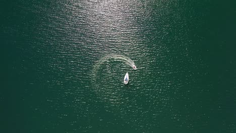 Una-Lancha-Rápida-Moviéndose-En-Movimiento-Circular-Hacia-El-Barco-Turístico-Varado-En-Medio-Del-Océano-Turquesa-En-Alaska---Toma-Aérea-De-Drones