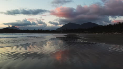 Arena-De-Playa-Húmeda-Que-Refleja-El-Cielo-Crepuscular-En-Cox-Bay,-Tofino,-Canadá