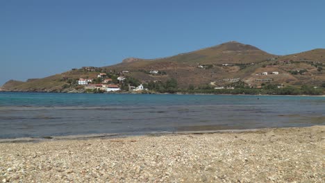 static view over rocky beach, ocean and hills with houses in the background