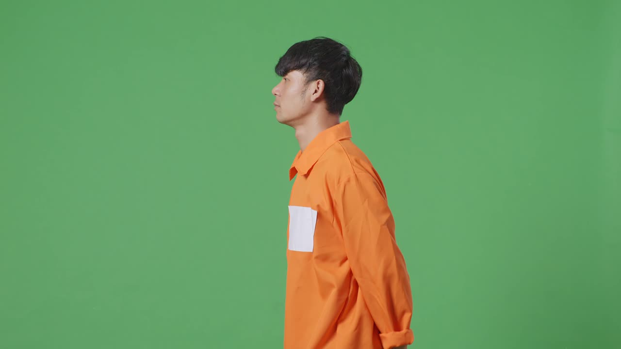 녹색 스크린 배경에서 손을 고 있는 아시아 남성 죄수