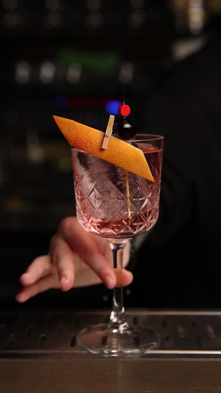 Un barman che prepara un cocktail rosa