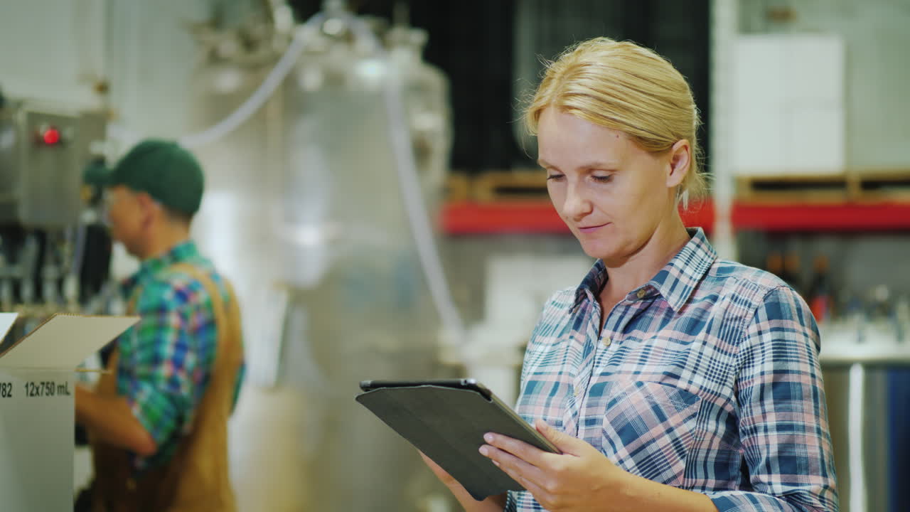 Worker Working With A Tablet On The Background Of The Conveyor In The Background Beverage Industry