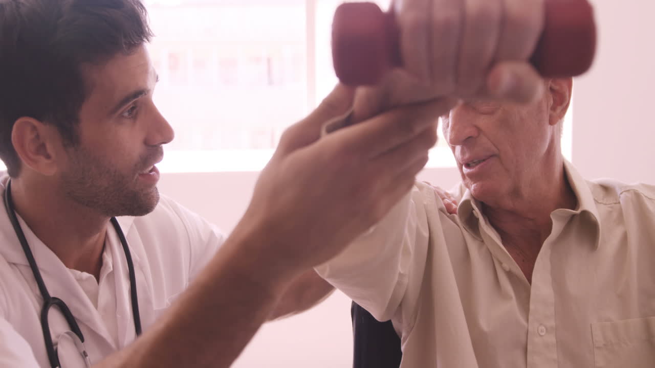 Male doctor assisting senior man to exercise