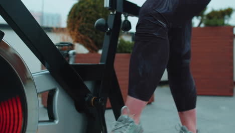 Close-up-athletic-woman-leg-spinning-exercising-workout-on-stationary-cycling-machine-bike,-outdoors