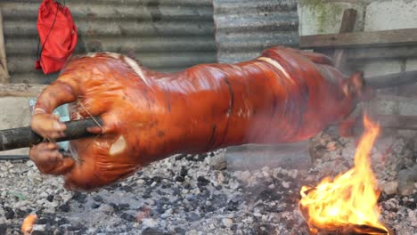 22-De-Abril-De-2023-Ciudad-De-Danao,-Cebu,-Filipinas:-Un-Lechon-Baboy-O-Cochinillo-Con-Una-Piel-Roja-Crujiente-Se-Está-Asando-Sobre-Fuego-De-Carbón