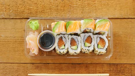 Sushi-Rollen-Mit-Lachs-Im-Plastikbehälter