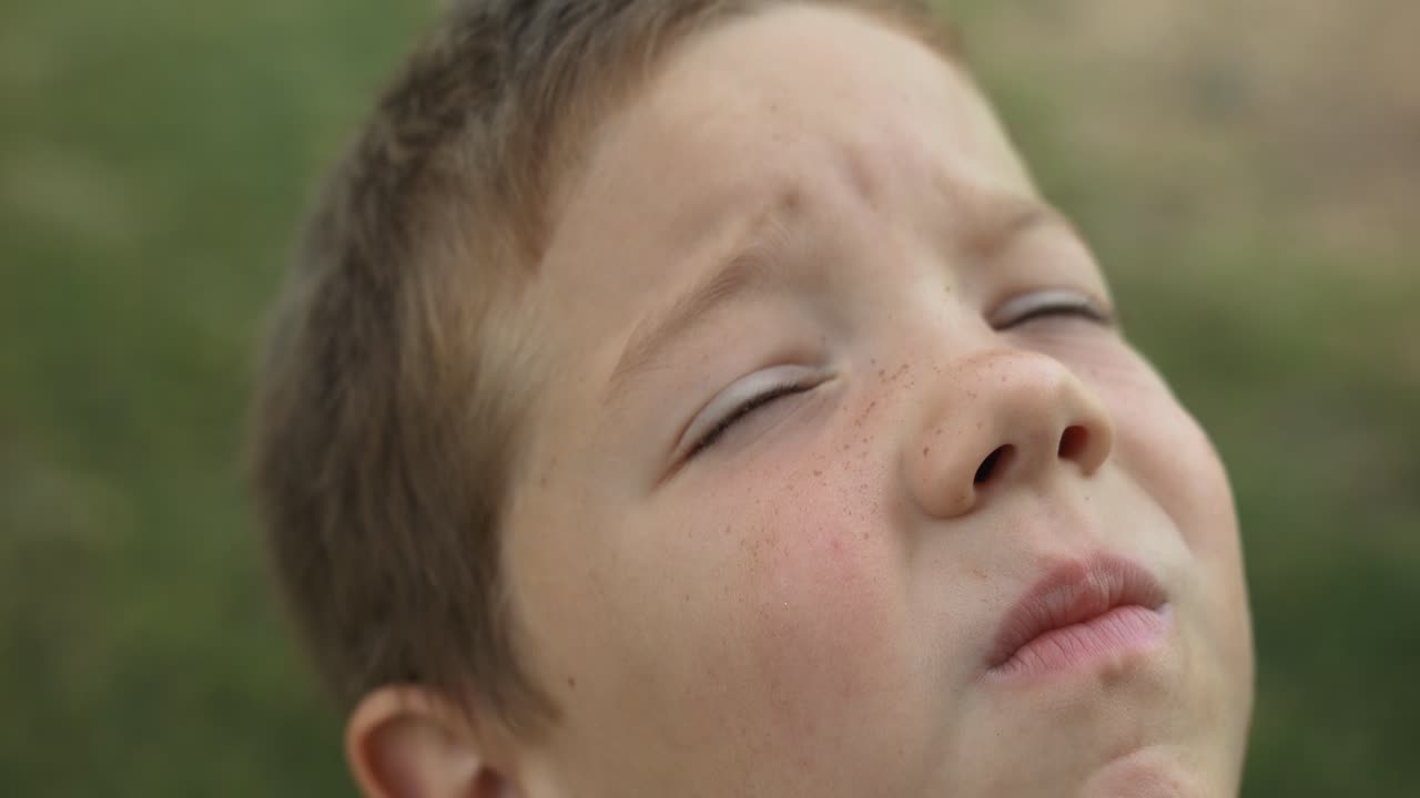 A contemplative child looks up toward the sky in a moment of quiet reflection. This cinematic stock video captures the innocence and imagination of childhood wonder and curiosity.