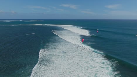 Kitesurfistas-Surfeando-Sobre-Las-Olas-En-Mauricio,-Fotografía-Tomada-Con-Un-Dron