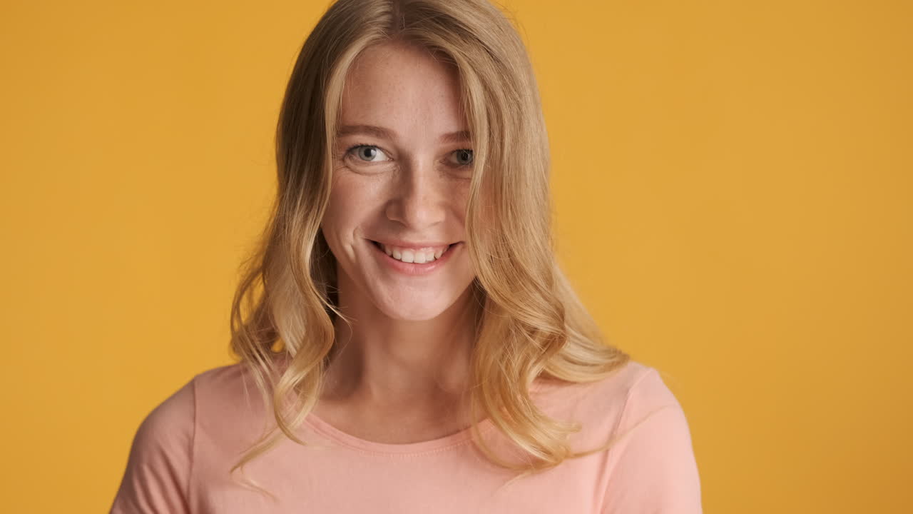 Caucasian woman calmly looking and smiling at camera.