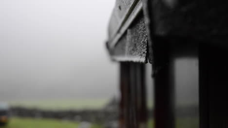 water drips off a roof in the rain as the camera shifts focus