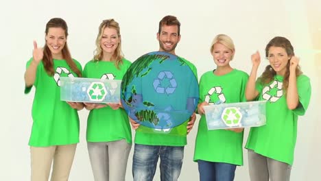 Animation-of-globe-over-smiling-caucasian-volunteers-with-recycling-boxes