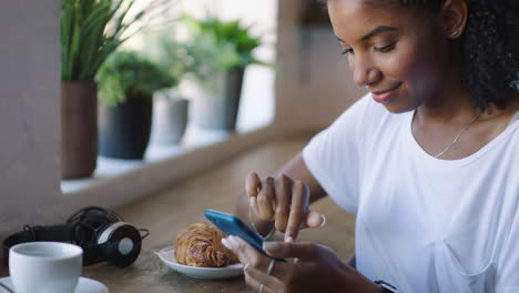 young woman using smartphone in a cafe