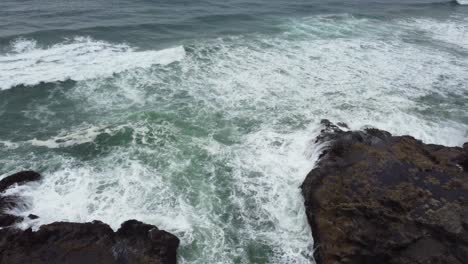 4K-30FPS-Aerial-Footage-of-Thor's-Well,-Spouting-Horn-into-Endless-Pacific-Ocean-View---Aerial-View-Turquoise-Blue-Water,-Mossy-Rock,-Waves-Crashing---Flying-Tracking-Shot-Smooth-DJI-Drone