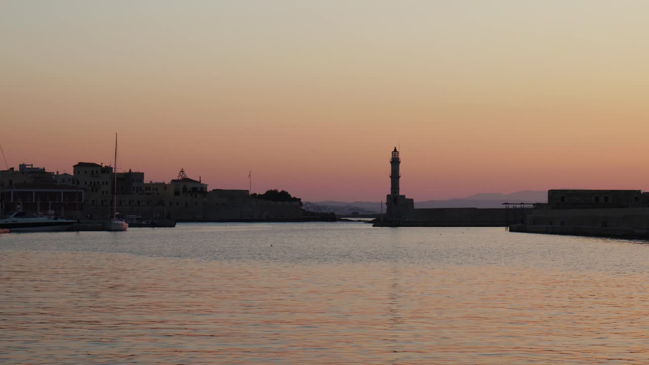 Splendida vista del tramonto sul Mar Egeo a Chania, vecchio porto veneziano con faro storico durante una sera d'estate, attrazione turistica in Grecia.
