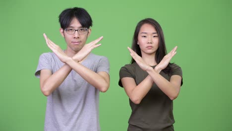young asian couple with stop gesture together