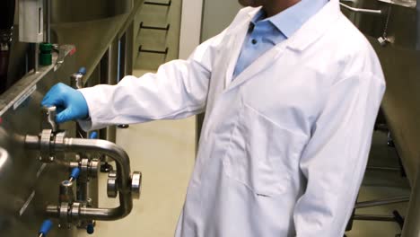 brewer examining brewery machine at brewery factory