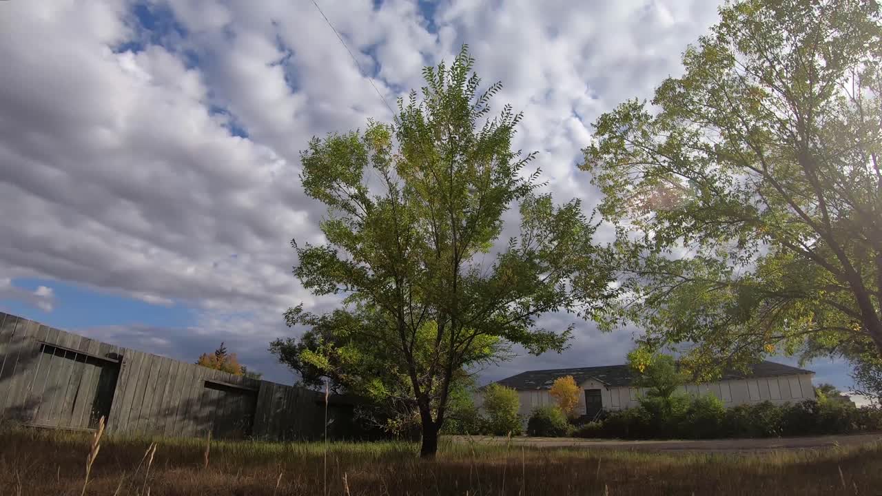 Thick clouds moving over head of a yard in a small town across from an old abandoned hospital near Alberta Canada