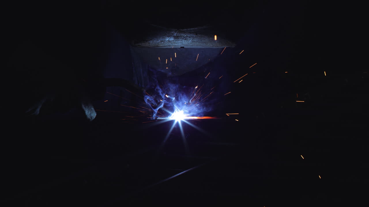 Close-up shot of a welder at work, sparks flying