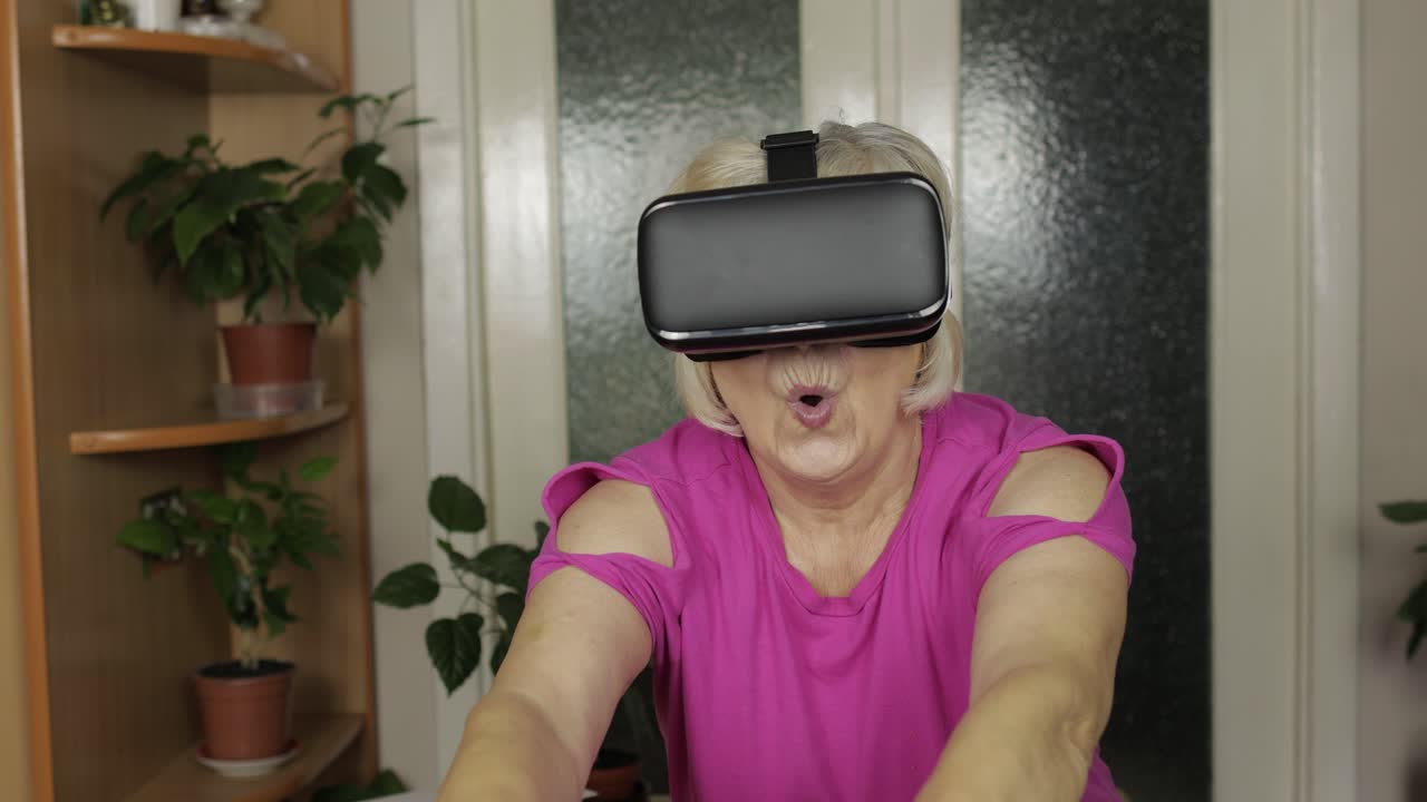 Nonna anziana donna con occhiali virtuali che guarda video 3D in 360 vr casco a casa