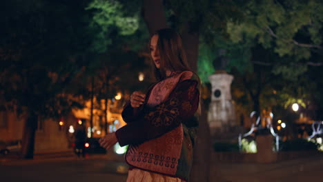 carefree girl walking dusk city park turning to camera with smile. relaxed woman