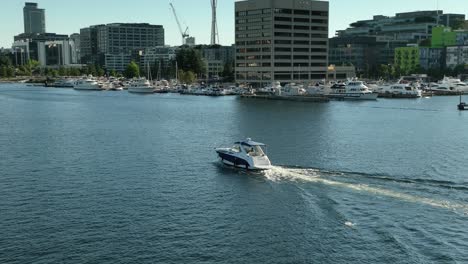 drone shot of a boat traveling through south lake union in downtown seattle