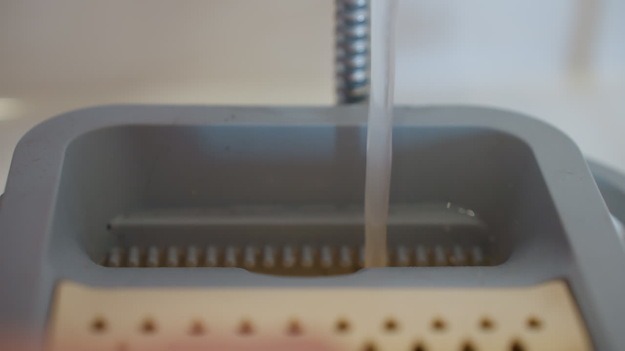 Close up of water pouring from tap into cleaning bucket, showing preparation for household chores with focus on sanitation, hygiene, and domestic maintenance tools in everyday cleaning routine