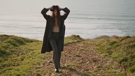 relaxed girl walking green coast at sunny evening. happy woman enjoying ocean.