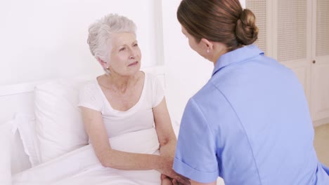 Nurse-talking-to-senior-woman-in-the-bed