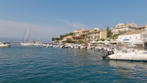 panning shot of the harbour in kassiopi, with a boat coming in to dock