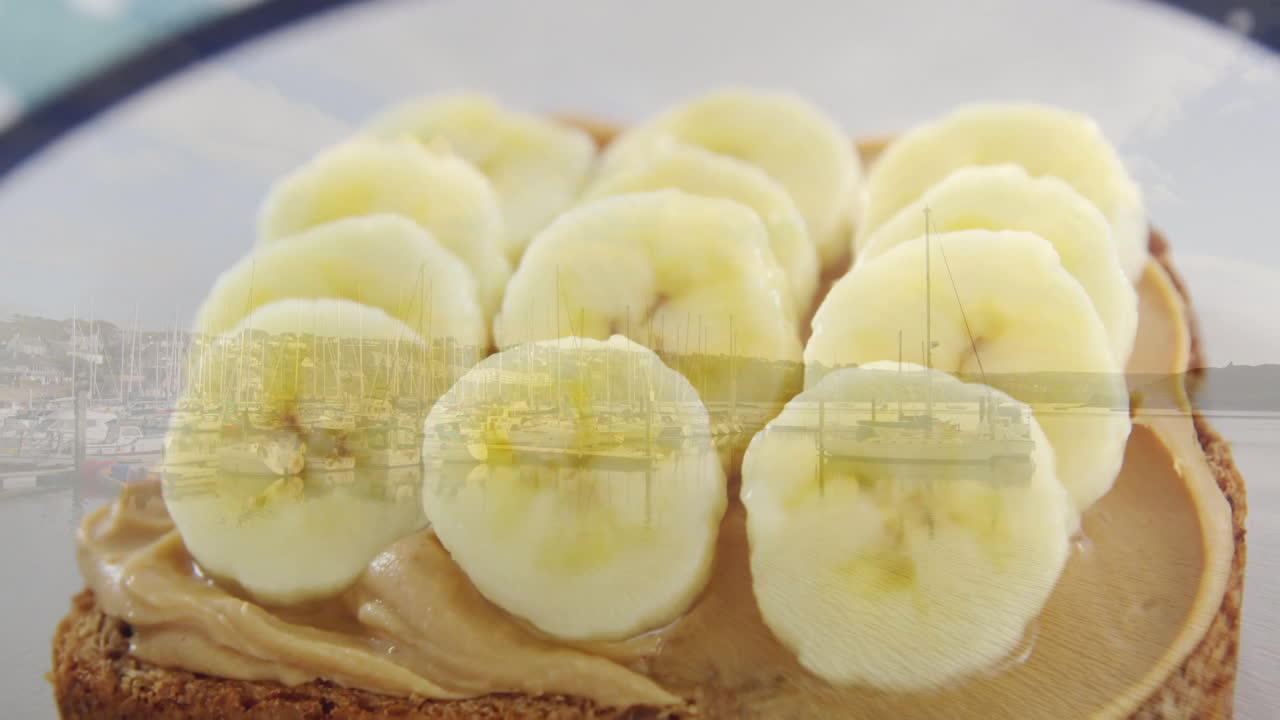 Banana slices on peanut butter toast overlooking marina with boats