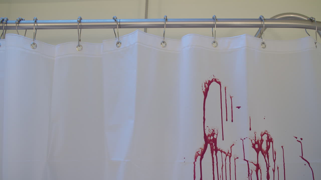 plano medio de sangre rociada en una cortina de baño