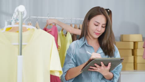 mujer trabajando en una tableta en un negocio de moda