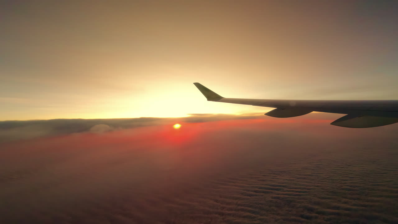 Solnedgang eller soloppgang sett fra vinduet på et kommersielt passasjerfly